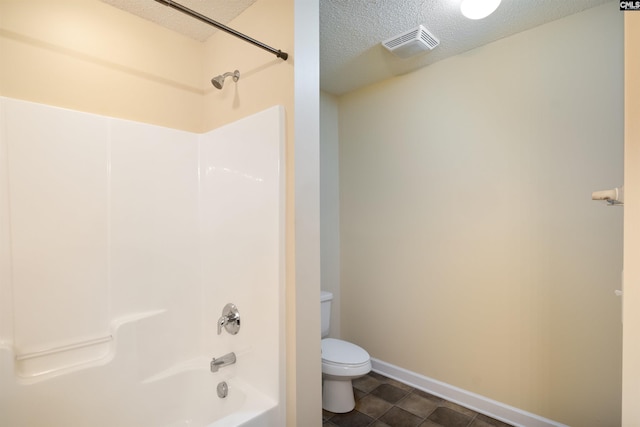 bathroom with bathtub / shower combination, a textured ceiling, and toilet