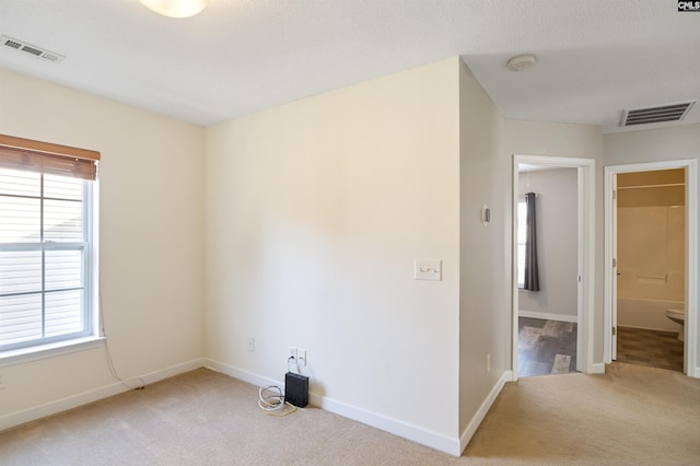 unfurnished room featuring light carpet