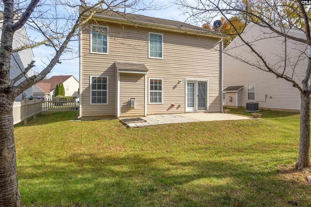 rear view of property with a patio, central air condition unit, and a lawn