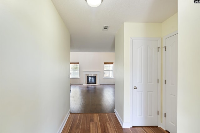 hallway featuring hardwood / wood-style floors and a textured ceiling