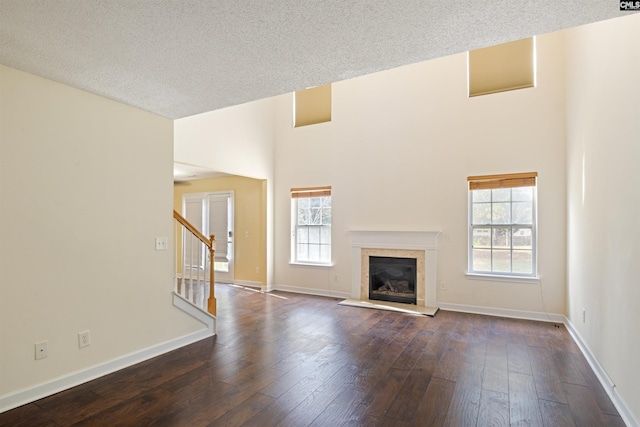 unfurnished living room with a textured ceiling, dark hardwood / wood-style floors, and plenty of natural light