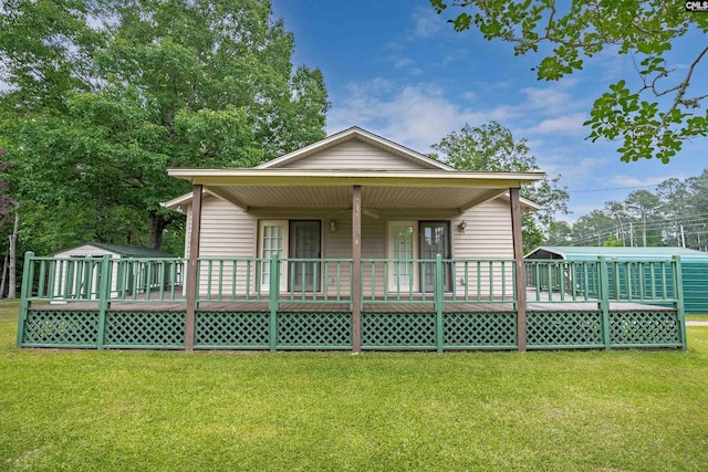 back of property featuring a deck and a yard