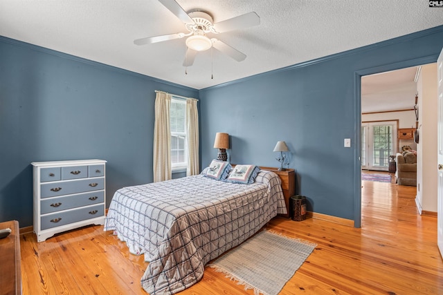 bedroom featuring a textured ceiling, hardwood / wood-style flooring, ceiling fan, and ornamental molding