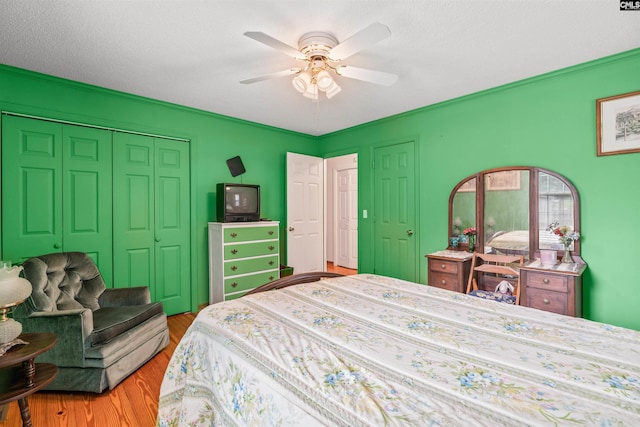 bedroom featuring ceiling fan, light wood-type flooring, and a textured ceiling