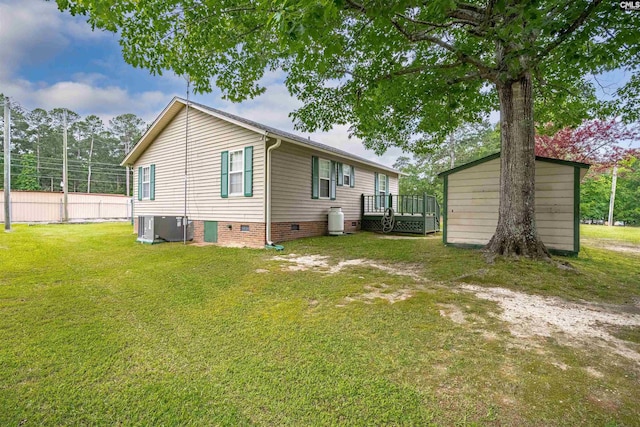 back of property featuring a lawn, central AC unit, and a wooden deck