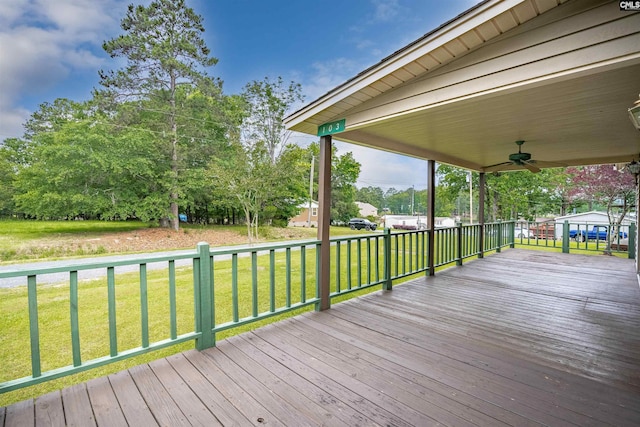 wooden terrace featuring a lawn and ceiling fan