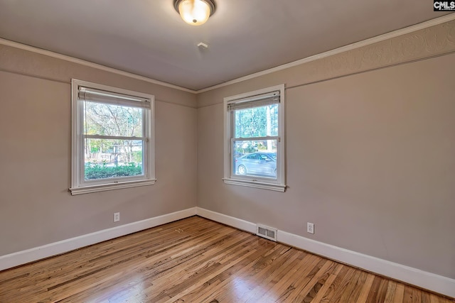 empty room with light wood-type flooring and crown molding