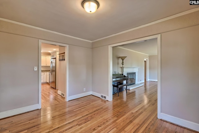 unfurnished room featuring crown molding and light hardwood / wood-style floors