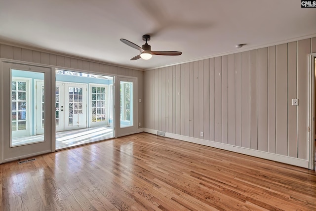 unfurnished room featuring light hardwood / wood-style floors, ceiling fan, and ornamental molding