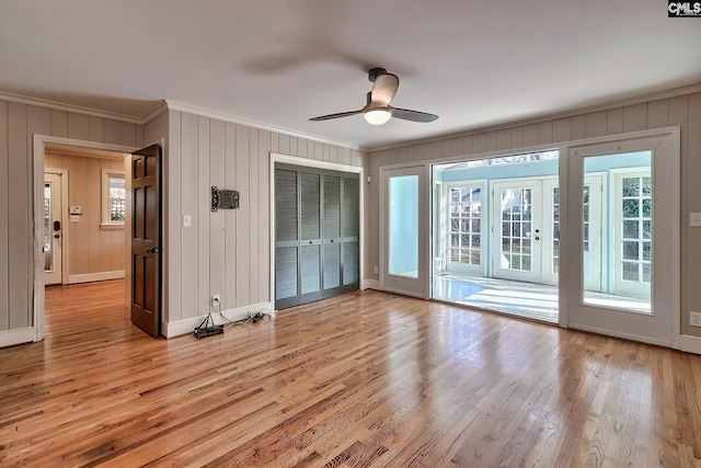 interior space with ceiling fan, light hardwood / wood-style floors, a healthy amount of sunlight, and crown molding