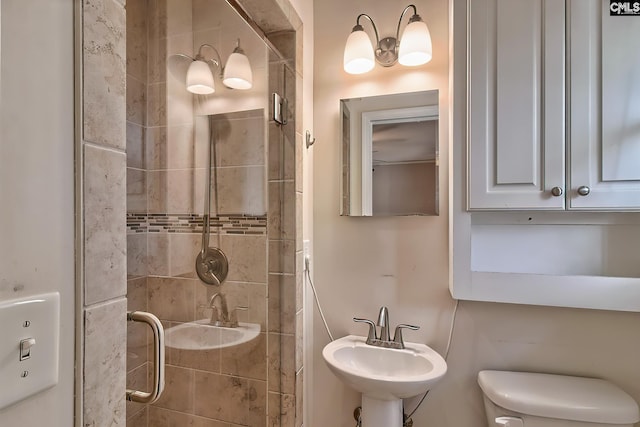 bathroom featuring sink, an enclosed shower, and toilet