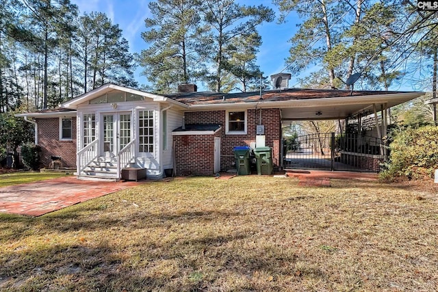 rear view of property featuring a yard and a carport