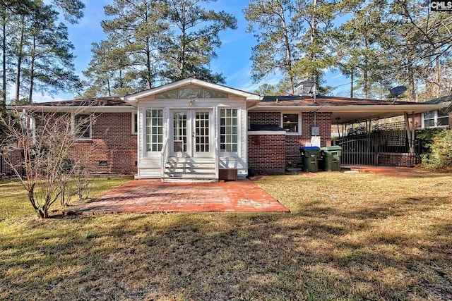 back of house with a carport and a yard