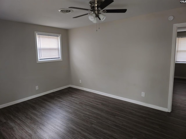 spare room with dark hardwood / wood-style floors, ceiling fan, and a wealth of natural light