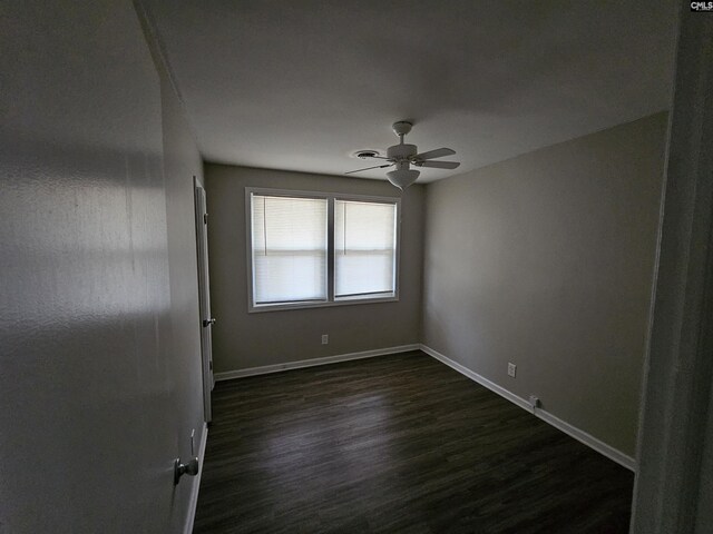 unfurnished room with ceiling fan and dark wood-type flooring