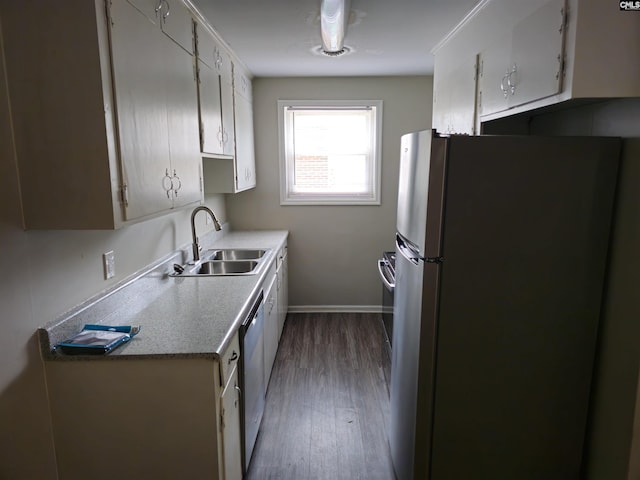 kitchen with white cabinets, appliances with stainless steel finishes, dark hardwood / wood-style flooring, and sink