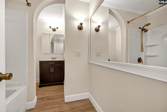 bathroom with hardwood / wood-style floors, a textured ceiling, shower / tub combination, vanity, and ornamental molding