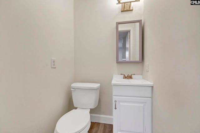 bathroom featuring vanity, hardwood / wood-style flooring, and toilet