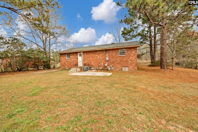 rear view of property featuring central AC unit, a patio area, and a lawn