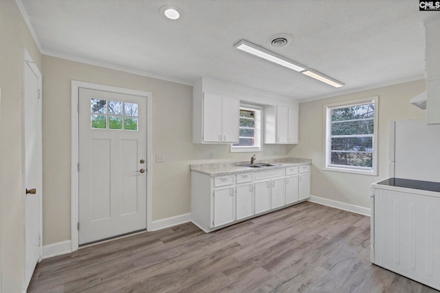 kitchen featuring white refrigerator, white cabinetry, sink, and light hardwood / wood-style flooring