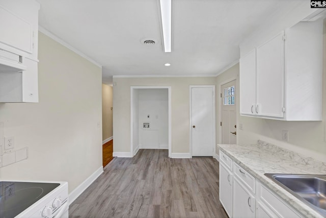 kitchen featuring white cabinets, sink, light wood-type flooring, and crown molding