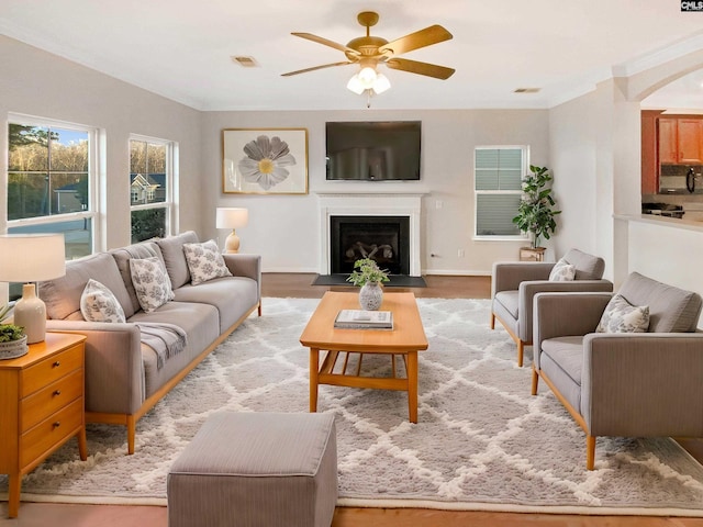 living room with ceiling fan, light hardwood / wood-style floors, and crown molding