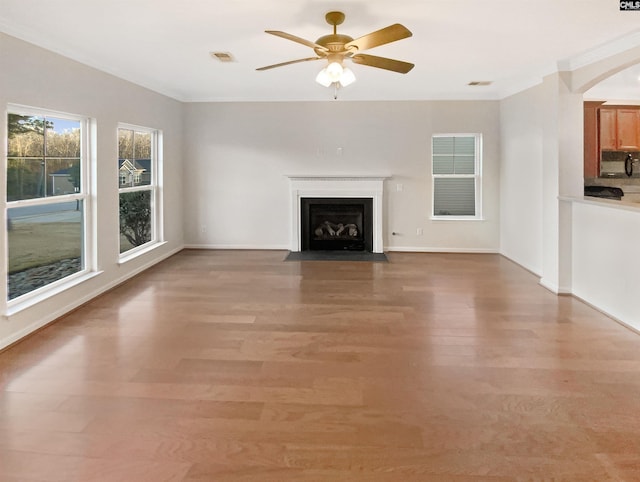 unfurnished living room with hardwood / wood-style flooring, ceiling fan, and ornamental molding