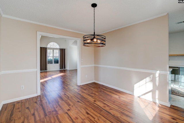 unfurnished room featuring crown molding, dark hardwood / wood-style floors, and an inviting chandelier