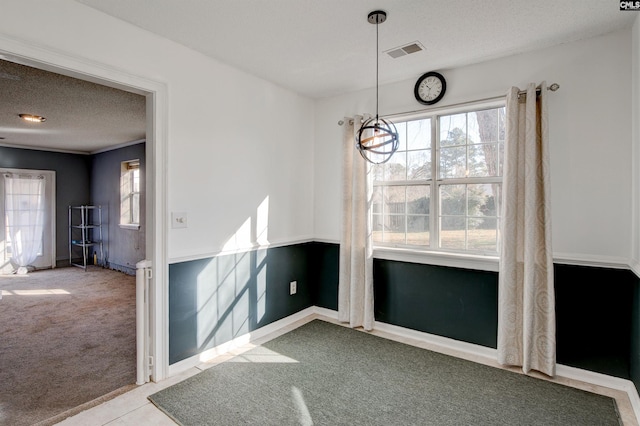 unfurnished dining area with a wealth of natural light, light carpet, and a textured ceiling