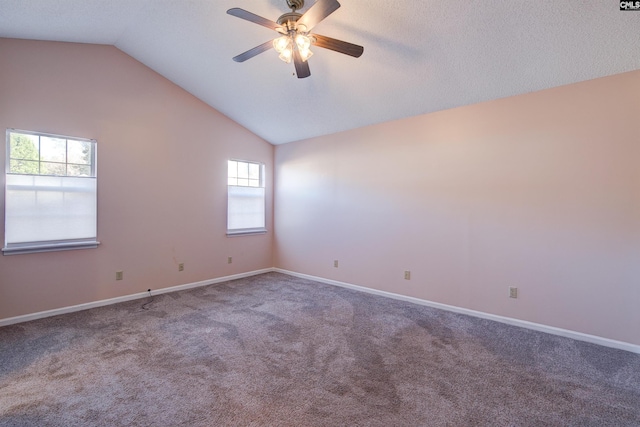 carpeted empty room featuring ceiling fan, a healthy amount of sunlight, and lofted ceiling