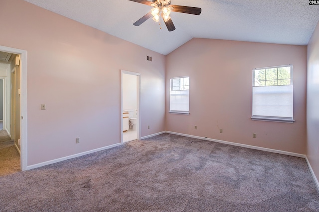 spare room with a textured ceiling, ceiling fan, carpet, and lofted ceiling