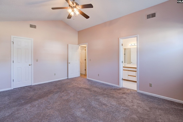 unfurnished bedroom featuring ceiling fan, carpet floors, high vaulted ceiling, and ensuite bath