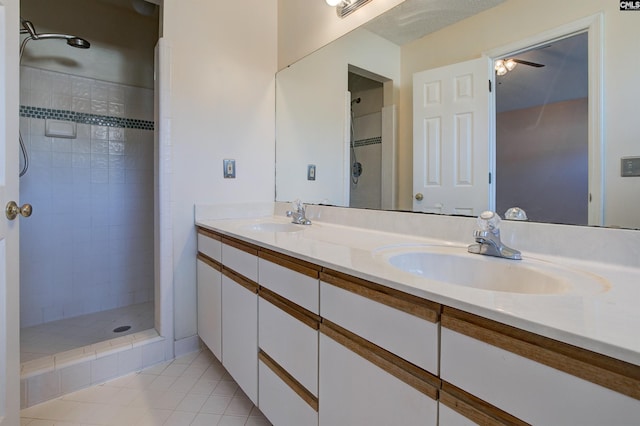 bathroom featuring tile patterned floors, ceiling fan, tiled shower, and vanity