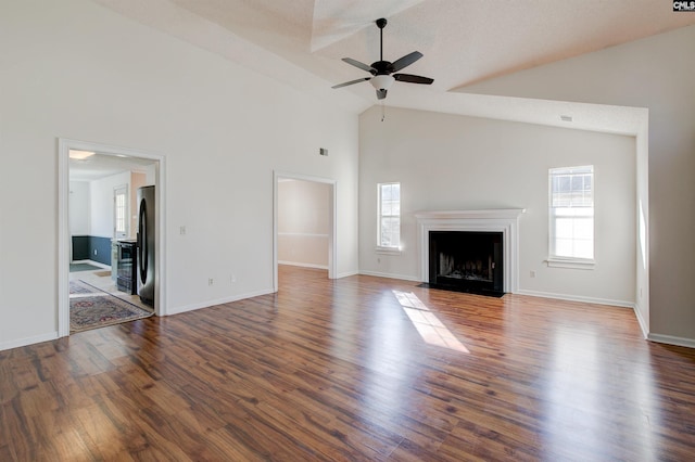 unfurnished living room featuring ceiling fan, dark hardwood / wood-style flooring, and high vaulted ceiling