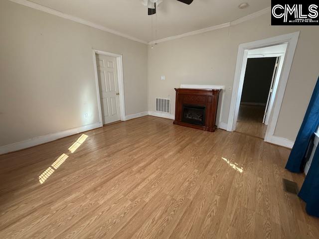 unfurnished living room featuring light hardwood / wood-style flooring, ceiling fan, and crown molding