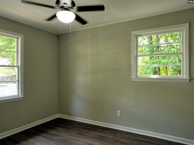 empty room featuring dark hardwood / wood-style flooring, a wealth of natural light, and ceiling fan