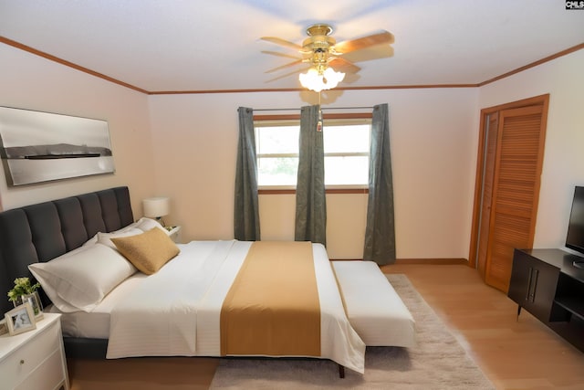 bedroom featuring light wood-type flooring, a closet, ceiling fan, and ornamental molding