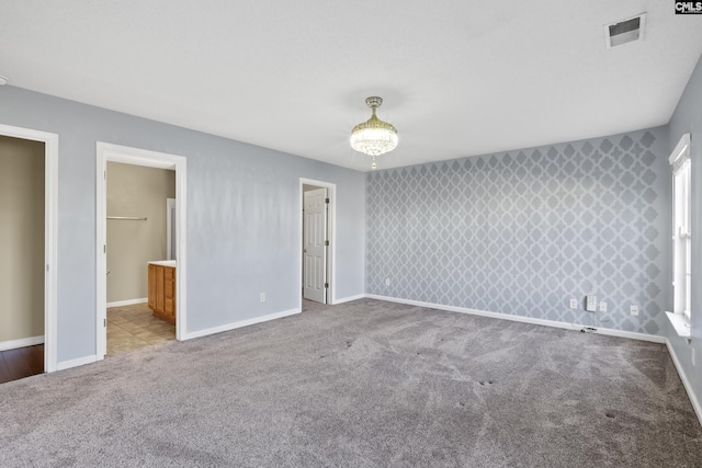 unfurnished bedroom featuring connected bathroom and light carpet