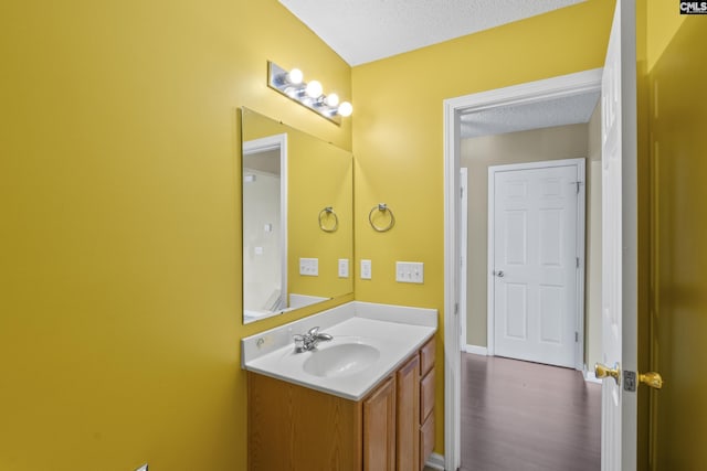 bathroom featuring hardwood / wood-style flooring, vanity, and a textured ceiling