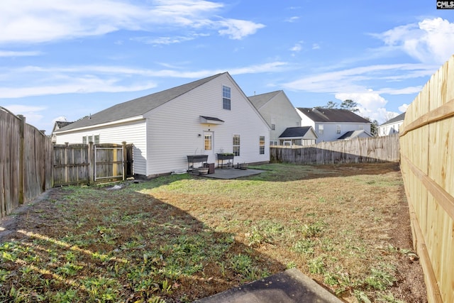 back of house featuring a lawn and a patio area