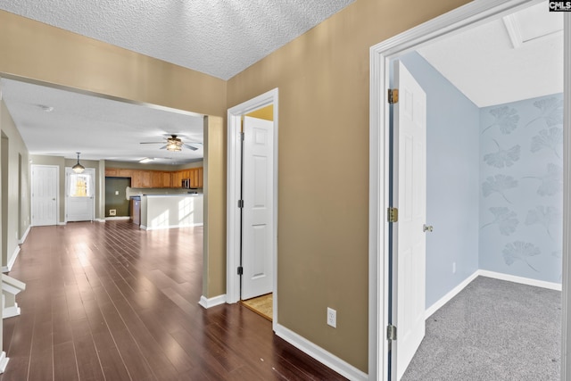 hallway featuring dark wood-type flooring and a textured ceiling