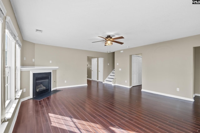 unfurnished living room featuring ceiling fan and dark wood-type flooring