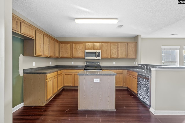 kitchen featuring electric range, sink, a textured ceiling, dishwashing machine, and a kitchen island