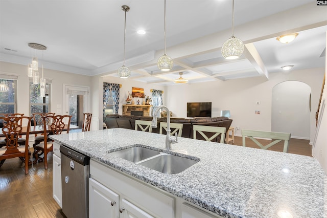 kitchen with dishwasher, white cabinets, pendant lighting, and sink