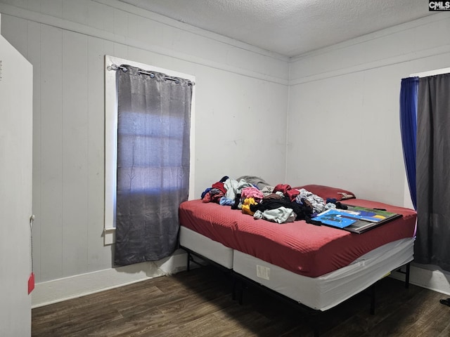 bedroom with dark hardwood / wood-style floors and a textured ceiling