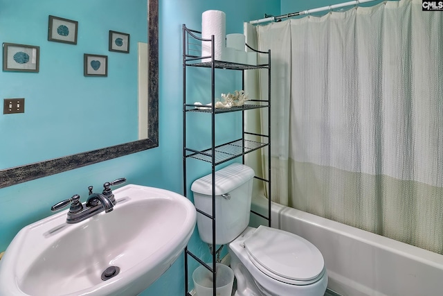 full bathroom featuring toilet, shower / bath combo with shower curtain, and sink