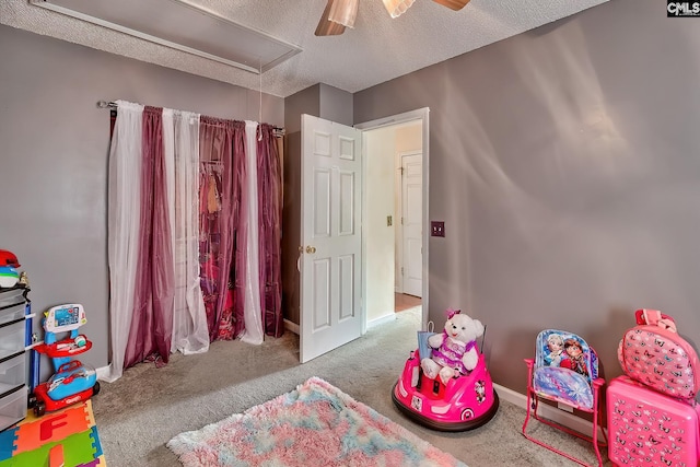 rec room with ceiling fan, carpet floors, and a textured ceiling