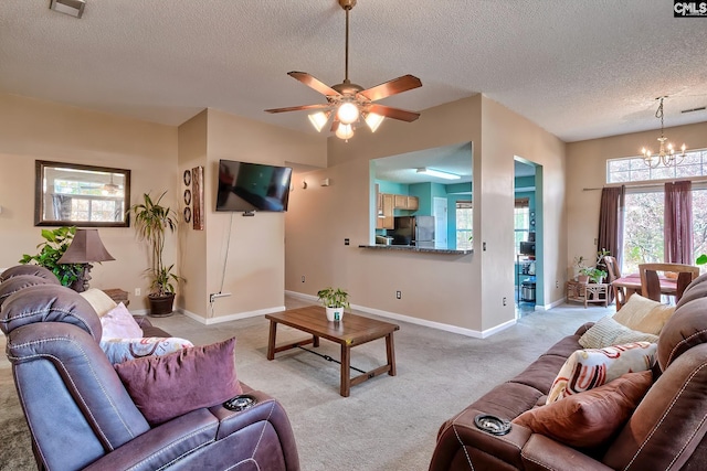 carpeted living room with ceiling fan with notable chandelier and a textured ceiling