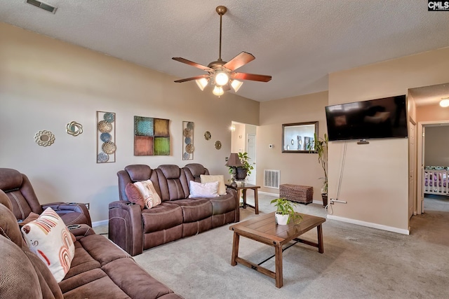 living room featuring light carpet, ceiling fan, and a textured ceiling