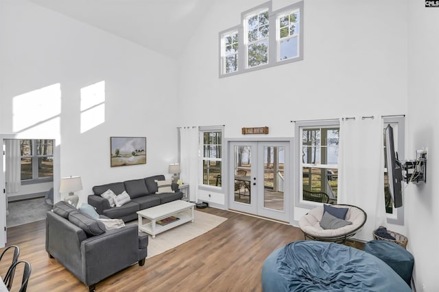 living room featuring french doors, high vaulted ceiling, and hardwood / wood-style floors